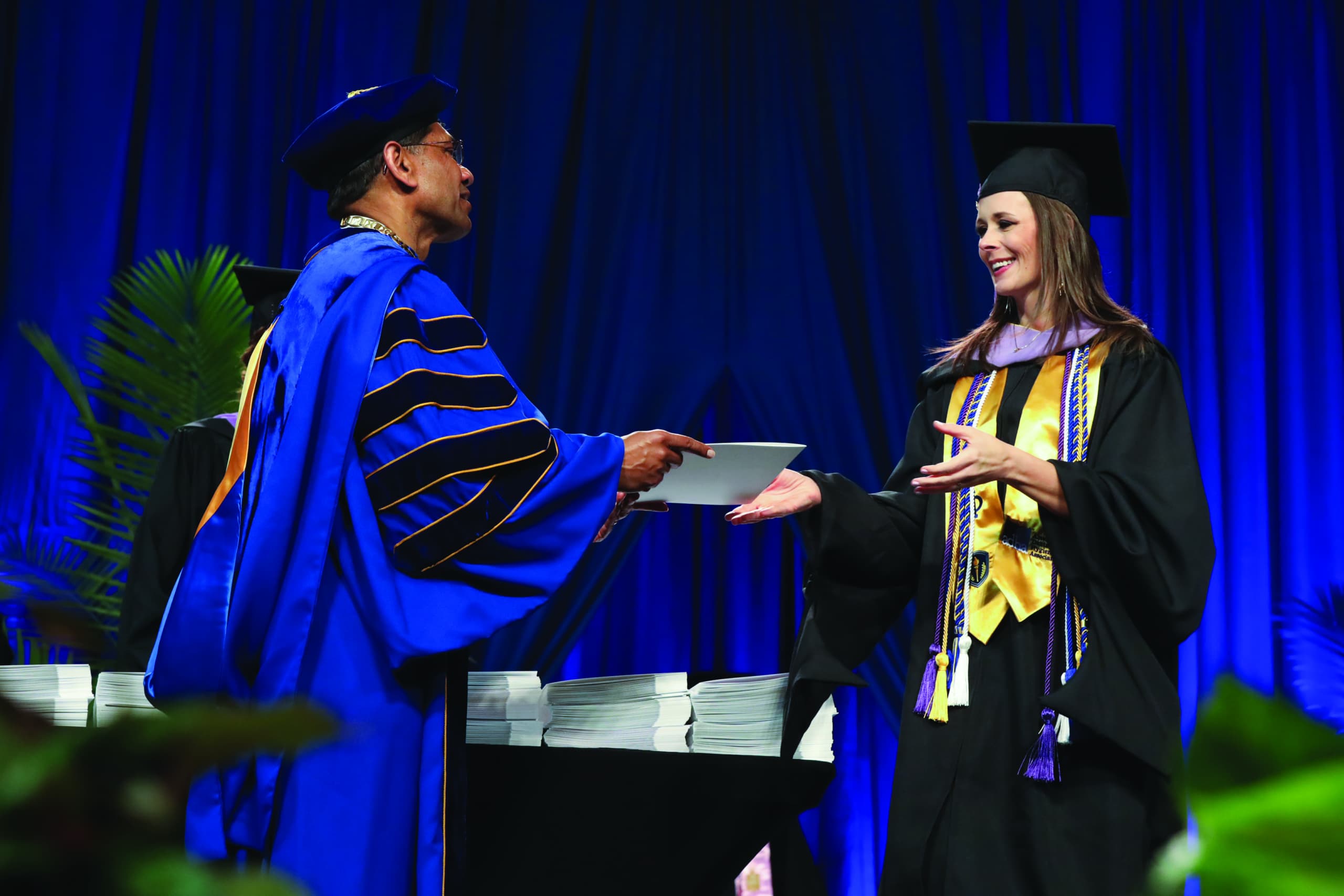 Chancellor handing diploma to gradute on stage