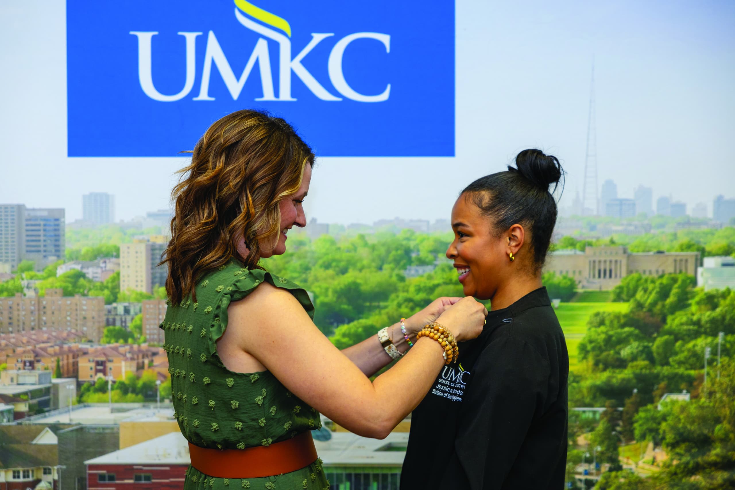 graduate being pinned by instructor