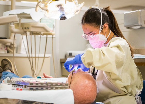 A dental student practices on a model simulator
